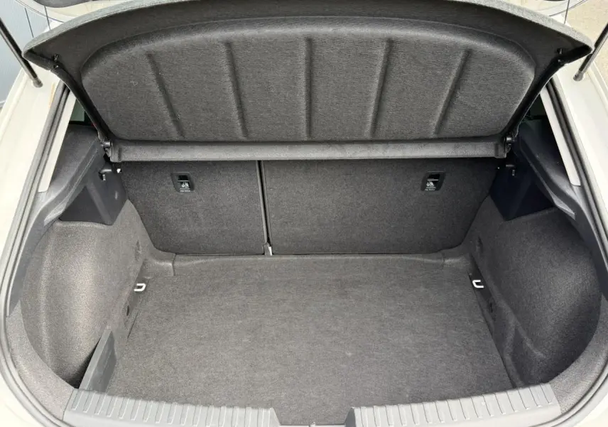 Coffre ouvert vu de l'arrière d'une SEAT LEON blanche, montrant un espace de chargement propre et spacieux.