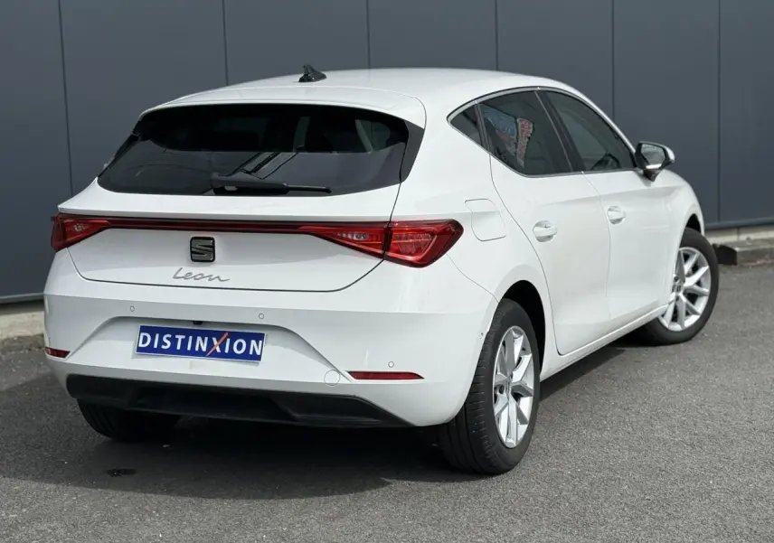 Vue 3/4 arrière droite d'une SEAT Leon blanche 2025 avec feux arrière LED et jantes alliage 16 pouces.