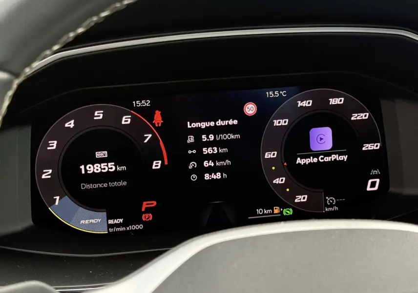 Affichage numérique du tableau de bord du SEAT Leon 2025 montrant la consommation, distance, vitesse et Apple CarPlay.