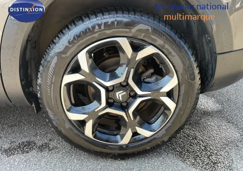 Gros plan sur la roue avant gauche du Citroën C5 Aircross gris platinium métal avec jante alliage noire et argentée.
