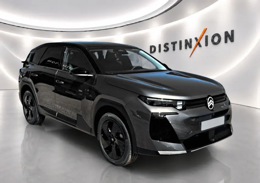 Citroën C5 Aircross 2026 gris platinium vue 3/4 avant droit dans un showroom lumineux avec toit noir.