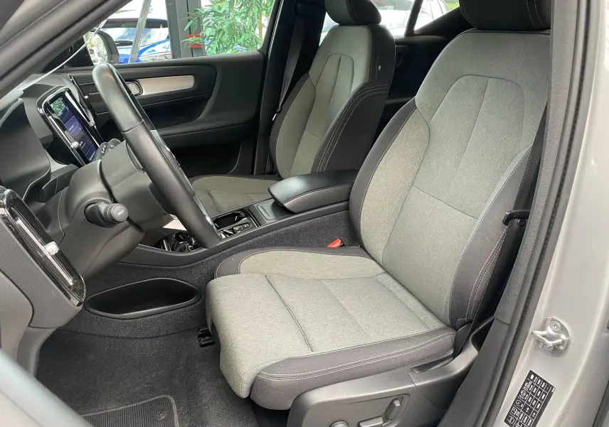Vue intérieure côté conducteur du Volvo XC40 B3 163ch Plus 2023, sièges gris clair et tableau de bord noir.
