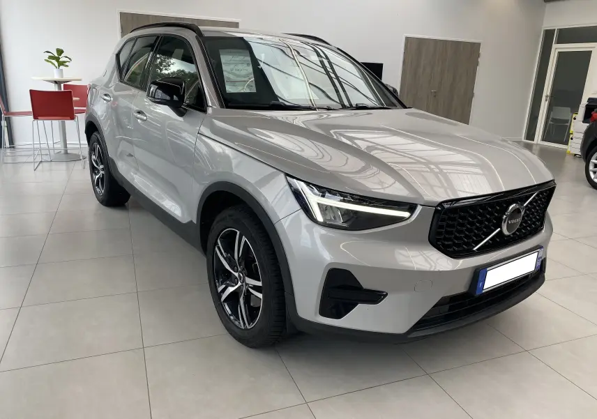 Volvo XC40 B3 163ch Plus 2023 en Argent Aurore métallisé, vue 3/4 avant avec calandre noire et jantes alliage.