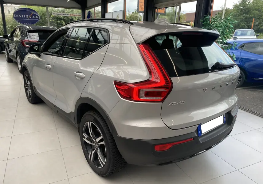 Vue 3/4 arrière droite du Volvo XC40 B3 163ch Plus 2023 en argent aurore métallisé, avec feux arrière LED caractéristiques.