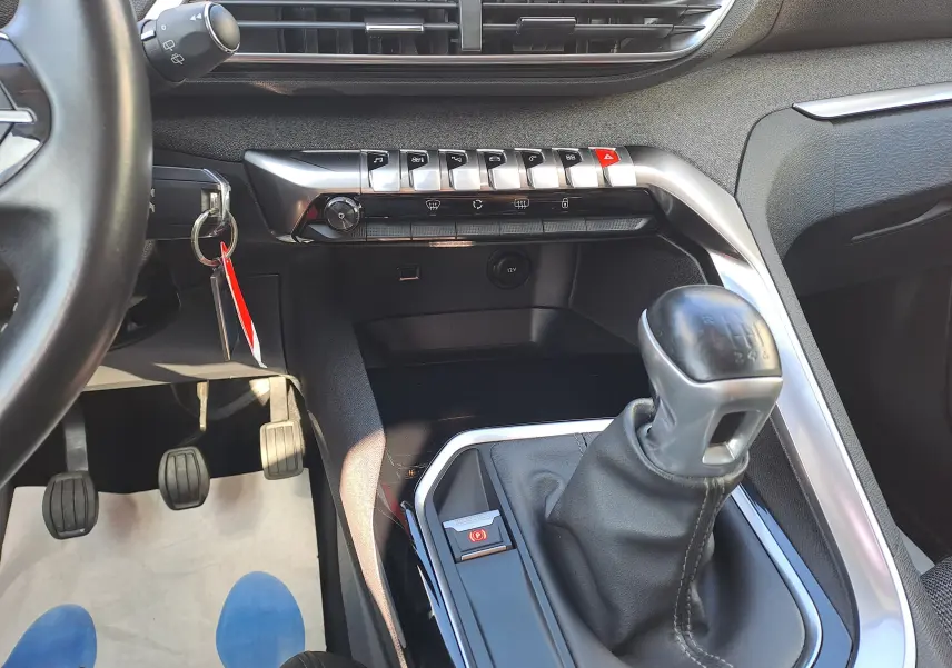 Intérieur du Peugeot 3008 2019 en vue rapprochée sur la console centrale avec levier de vitesse manuel et boutons argentés.