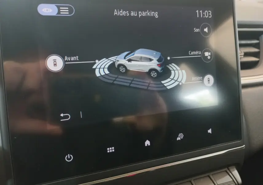 Écran tactile intérieur du Renault Captur Business TCe 100 montrant l'aide au parking avec vue 3D du véhicule gris clair.