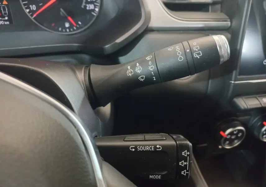 Gros plan sur les commandes au volant du Renault Captur gris clair 2020, avec leviers multifonctions et tableau de bord partiel.