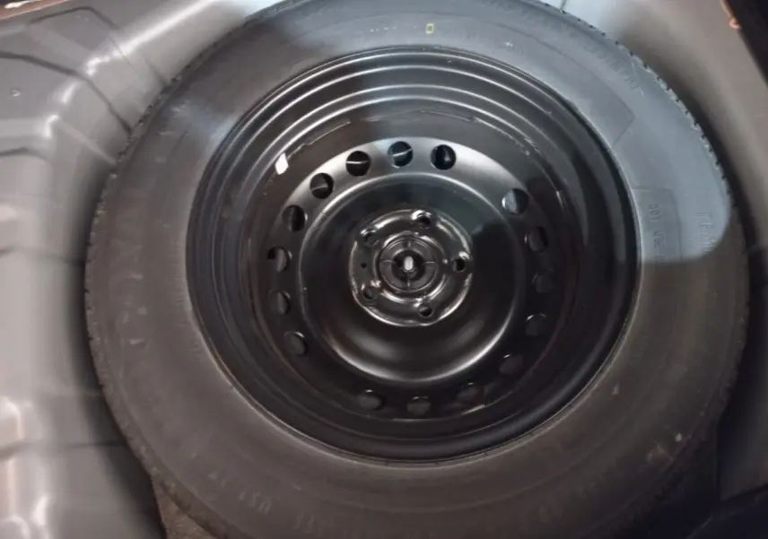 Gros plan sur la roue de secours noire dans le coffre du Renault Captur Business TCe 100 gris clair 2020.