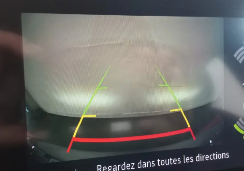 Vue arrière via caméra de recul du Renault Captur gris clair Business TCe 100 de 2020 avec lignes de guidage colorées.