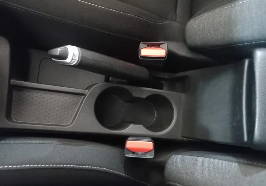 Vue rapprochée de la console centrale noire avec frein à main manuel et deux ceintures rouges dans un Renault Captur gris clair 2020.