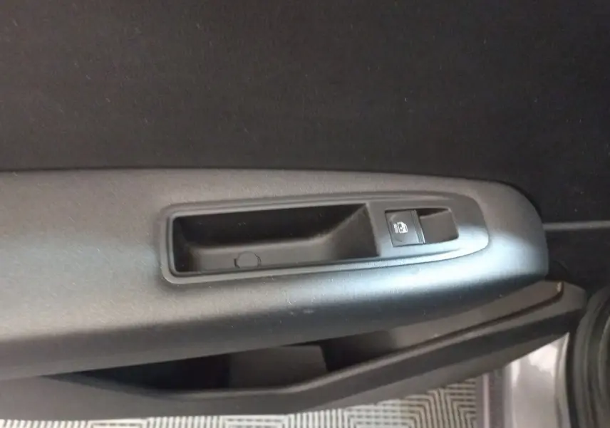 Détail de la poignée intérieure et bouton de verrouillage de porte côté gauche d'un Renault Captur gris clair 2020.