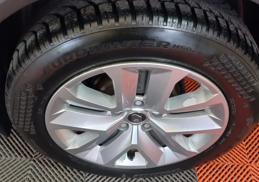 Gros plan sur la roue avant gauche d'un Renault Captur Business gris clair, montrant le pneu et la jante.