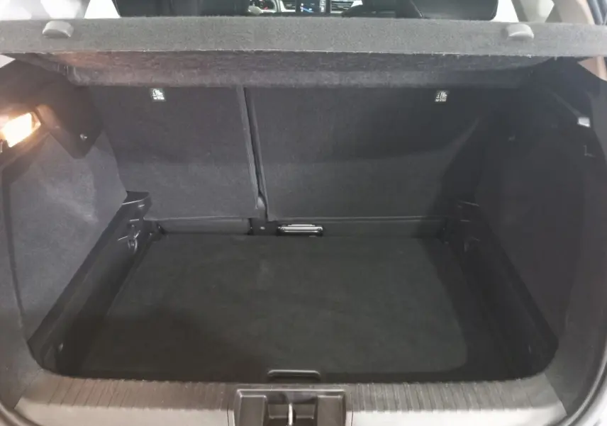 Coffre ouvert en vue arrière du Renault Captur Business TCe 100 gris clair, montrant l'espace de chargement vide.