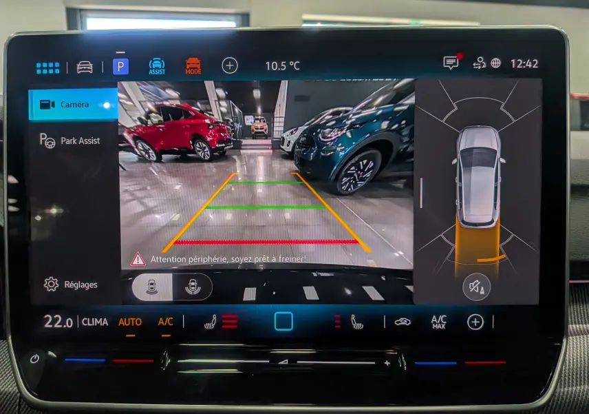 Vue de la caméra de recul sur l'écran multimédia d'une Volkswagen Golf gris dauphin, avec aides au stationnement visibles.