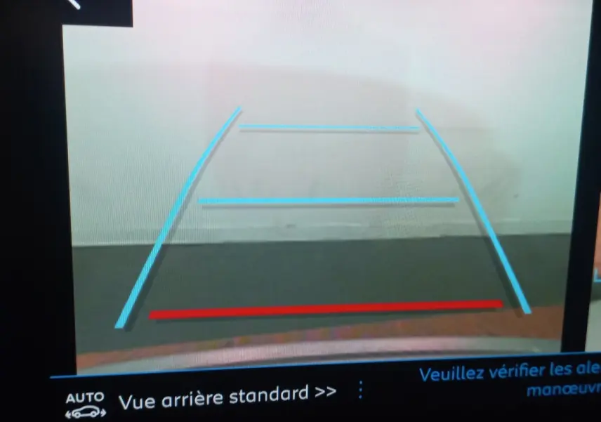 Vue arrière caméra de recul du Peugeot 3008 gris clair, avec lignes de guidage bleues et rouge visibles à l'écran.