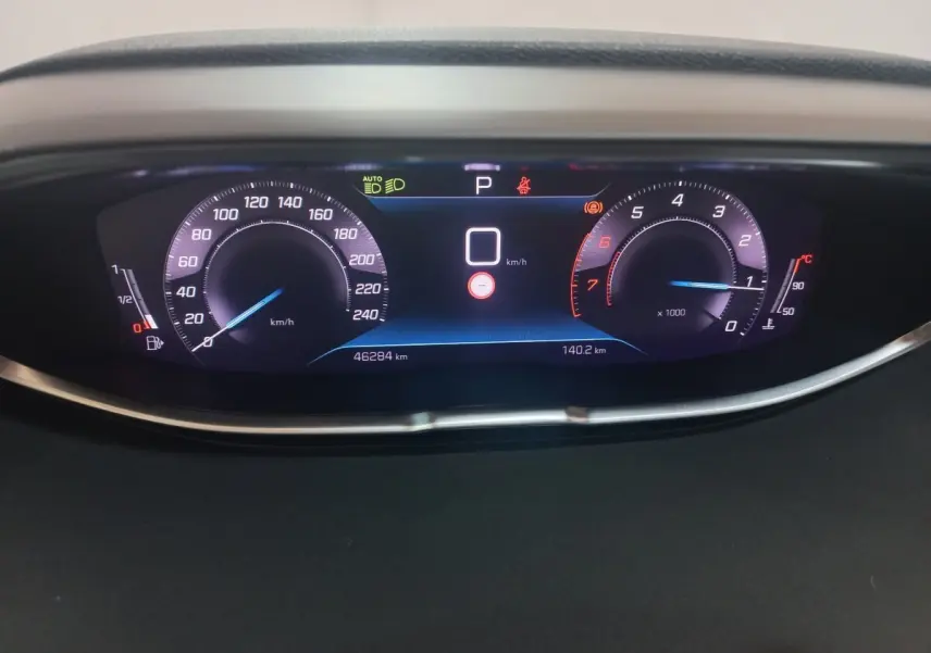 Affichage numérique du tableau de bord du Peugeot 3008 gris clair, montrant vitesse, compte-tours et jauge carburant.