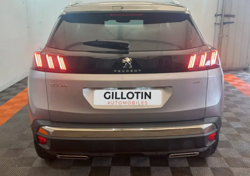 Vue arrière d’un Peugeot 3008 gris clair 2022 avec feux LED allumés et badge GT visible.