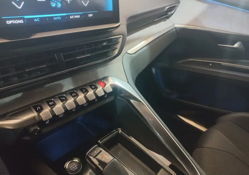 Vue intérieure côté passager du tableau de bord et console centrale du Peugeot 3008 GT gris clair avec écran tactile et commandes.