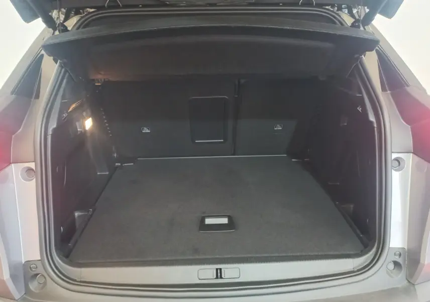 Coffre ouvert vu de l'arrière d'un Peugeot 3008 gris clair, montrant un espace de chargement propre et spacieux.