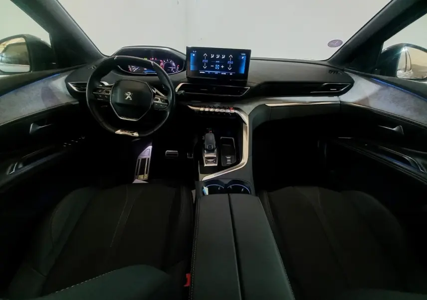 Vue intérieure avant du Peugeot 3008 GT 2022, tableau de bord moderne avec écran tactile central et volant cuir noir.