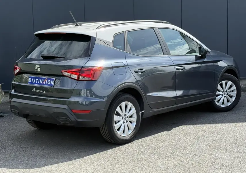 Vue 3/4 arrière droite du SEAT Arona gris magnétique avec toit blanc et jantes alliage 16 pouces sur fond urbain.