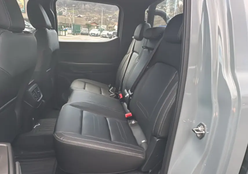 Vue intérieure côté droit des sièges arrière en cuir noir du Ford Ranger gris commandeur avec ceinture de sécurité visible.