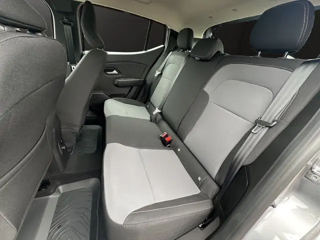 Vue latérale droite de l'habitacle arrière de la Dacia Sandero Stepway gris Urban avec sièges bicolores et tapis caoutchouc.