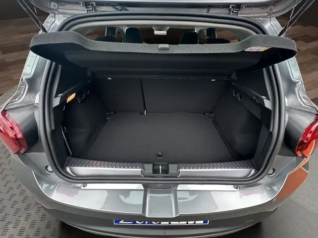 Coffre ouvert vu de l'arrière d'une Dacia Sandero Stepway TCE 110 Extreme Plus gris Urban, espace de chargement vide et propre.