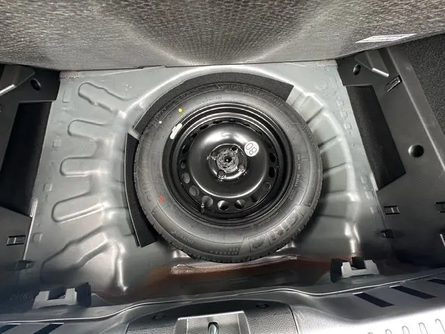 Roue de secours noire dans le coffre d'une Dacia Sandero Stepway TCE 110 Extreme Plus gris Urban 2025.