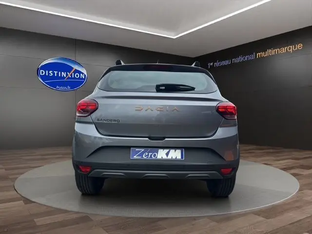 Vue arrière d'une Dacia Sandero Stepway TCE 110 Extreme Plus gris Urban avec feux LED et barres de toit noires.