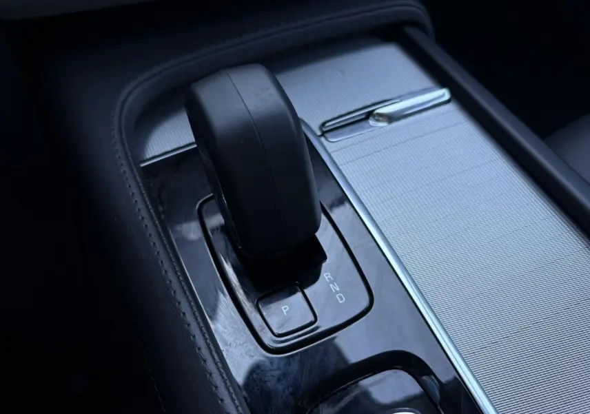 Gros plan sur le levier de vitesses automatique noir et la console argentée du Volvo XC90 T8 hybride 2024.
