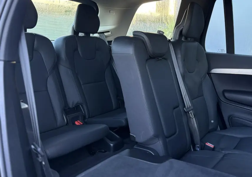 Intérieur du Volvo XC90 T8 2024, vue latérale des sièges arrière en cuir noir sur trois rangées.