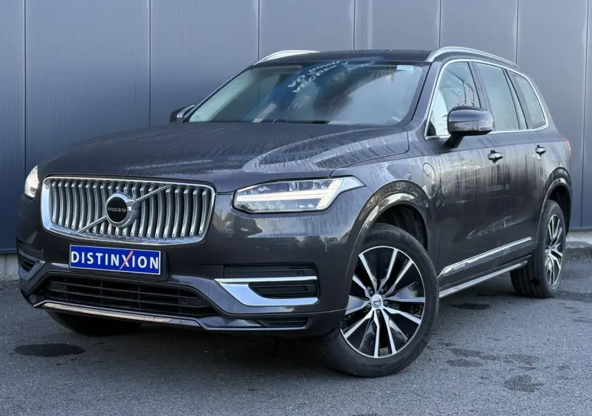 Volvo XC90 T8 hybride gris Platinium en 3/4 avant droit avec jantes alliage et calandre chromée distinctive.