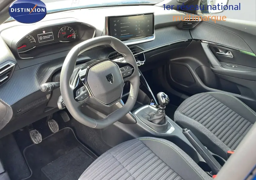 Intérieur de la Peugeot 2008 2024 en vue latérale droite, sièges noirs et volant compact avec écran tactile central.