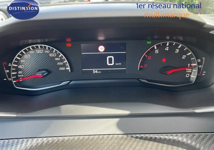 Tableau de bord numérique du Peugeot 2008 2024, affichage vitesse à 0 km/h et compte-tours avec fond noir texturé.