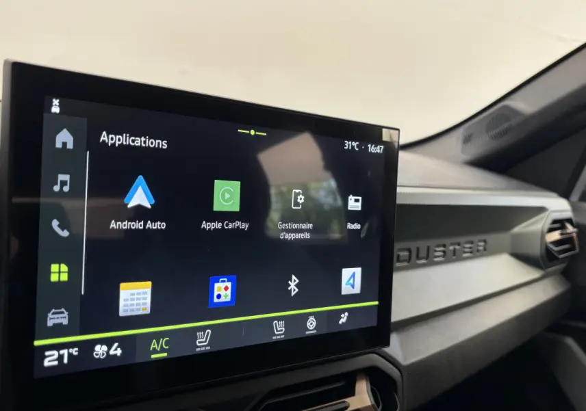 Écran tactile central du tableau de bord du Dacia Duster noir, affichant les applications Android Auto et Apple CarPlay.