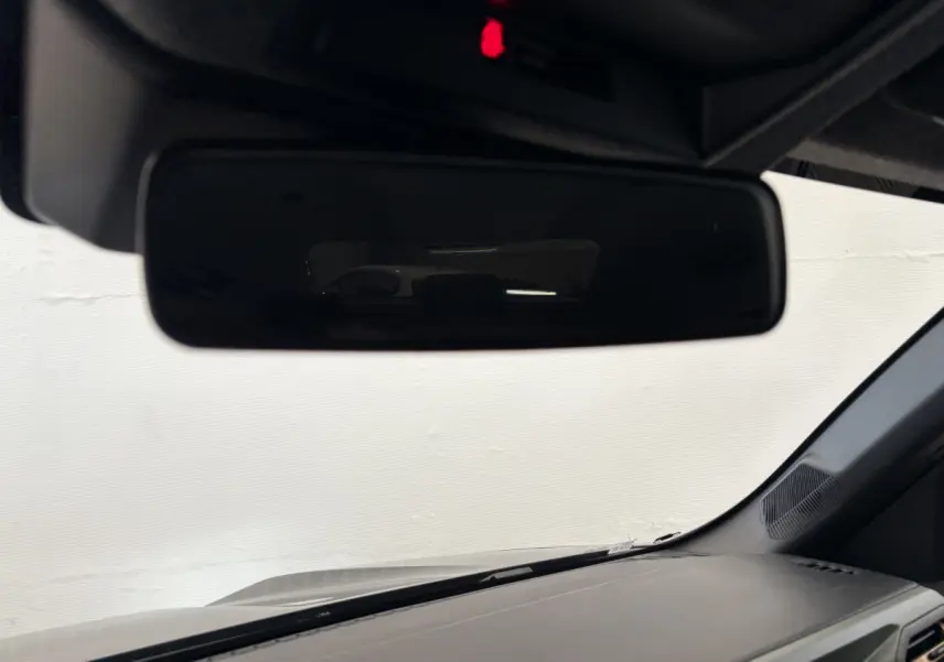 Vue intérieure du rétroviseur central du Dacia Duster 2025, tableau de bord noir et pare-brise visible