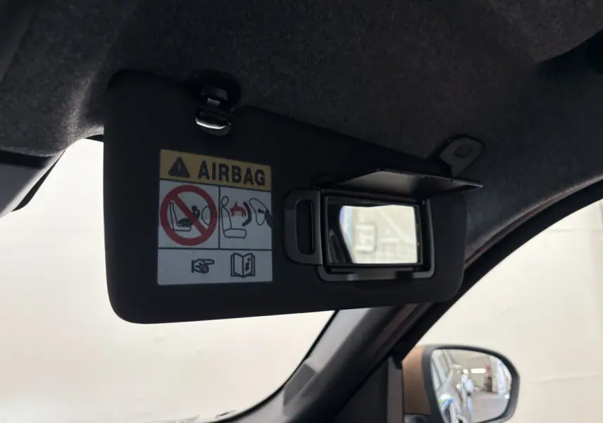 Miroir de courtoisie ouvert sur pare-soleil côté conducteur dans un Dacia Duster noir 2025, vue intérieure rapprochée.