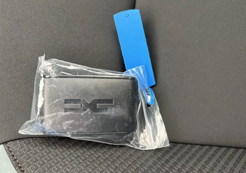 Clé noire Dacia Duster Extreme Mild Hybrid posée sur un siège tissu noir avec surpiqûres marron.