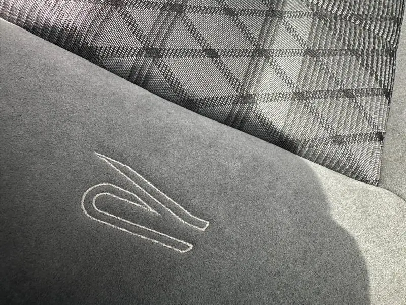 Détail du siège avant gris du Volkswagen T-Roc 2025 R-Line Edition avec logo R brodé et motif à carreaux.