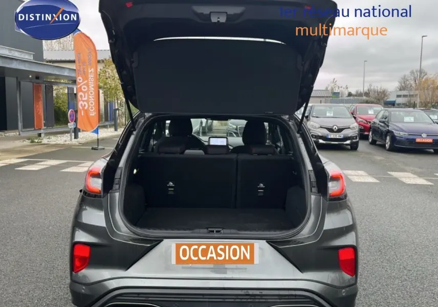 Vue arrière ouverte du Ford Puma gris magnétique 2024, mettant en valeur son coffre spacieux et ses feux arrière distinctifs.