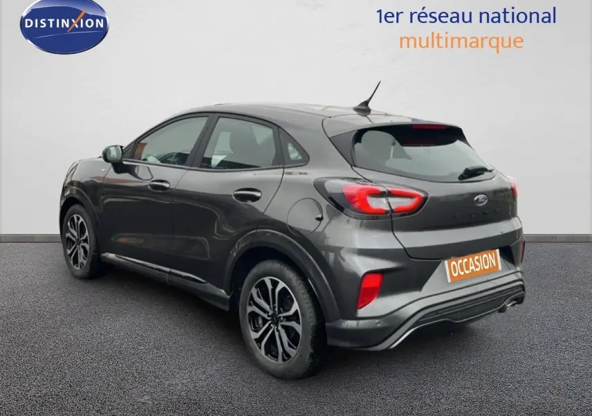 Ford Puma gris magnétique vue 3/4 arrière côté gauche, avec feux arrière LED et jantes alliage noires.