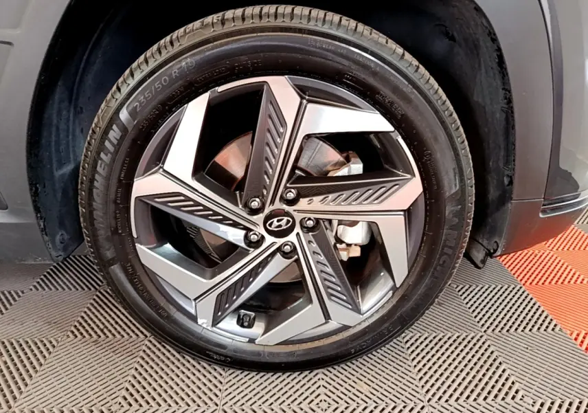Gros plan sur la jante alliage 19 pouces du Hyundai Tucson gris foncé, avec pneu Michelin visible.