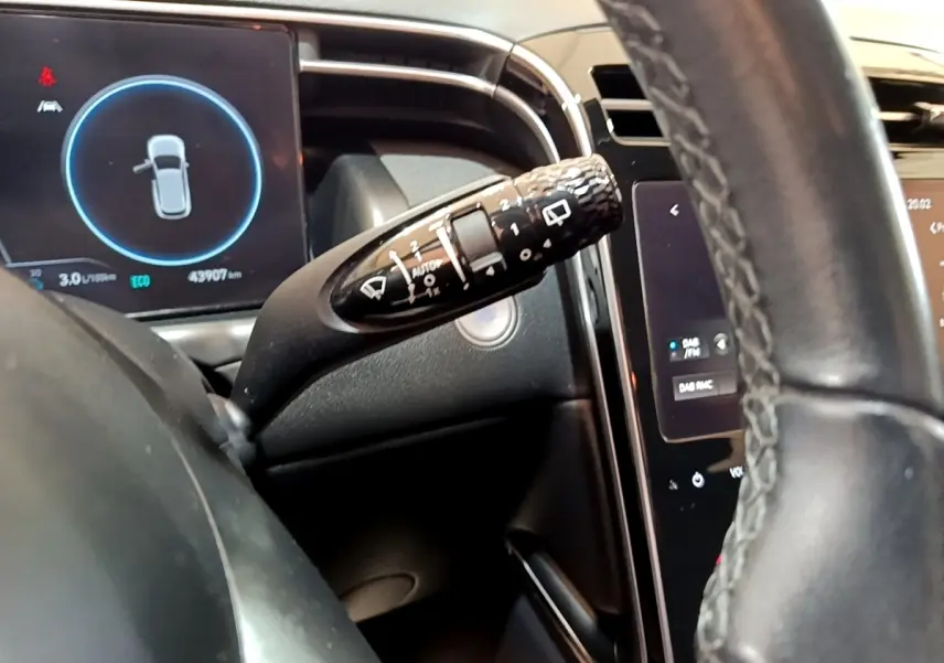 Gros plan sur la commande d’essuie-glace et le tableau de bord numérique du Hyundai Tucson gris foncé, intérieur moderne.