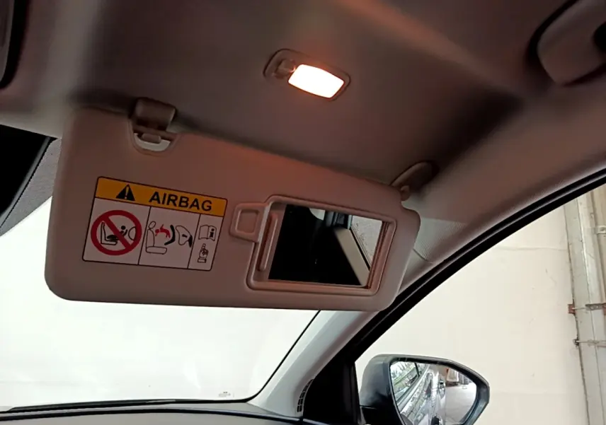 Détail intérieur du pare-soleil avec miroir et avertissement airbag, vue côté conducteur du Hyundai Tucson gris foncé.