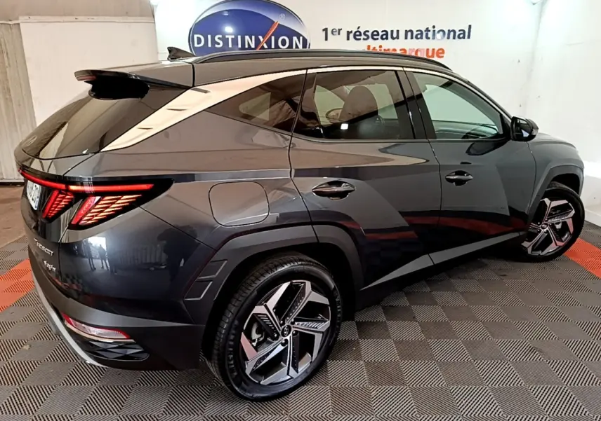 Vue 3/4 arrière droite du Hyundai Tucson gris foncé 2022 avec feux arrière LED et jantes alliage distinctives.