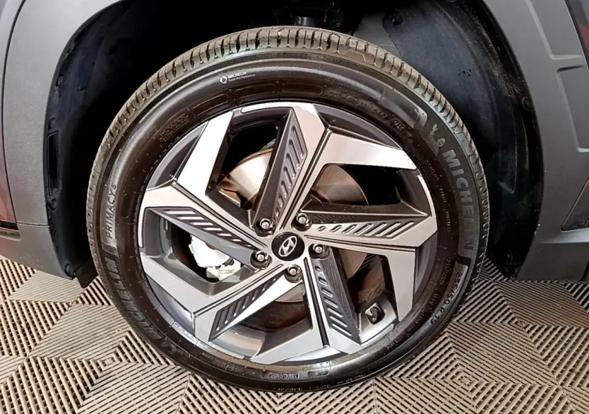 Gros plan sur la roue avant droite du Hyundai Tucson gris foncé, jante alliage à design moderne et pneu Michelin.