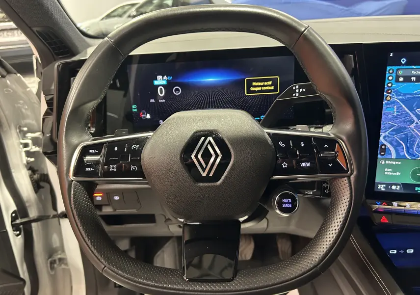 Vue rapprochée du volant cuir noir et du tableau de bord digital du Renault Austral 2024 en blanc nacré.