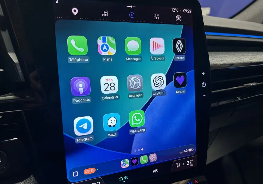 Écran tactile central du Renault Austral blanc nacré, affichant plusieurs applications connectées, vue intérieure côté droit.