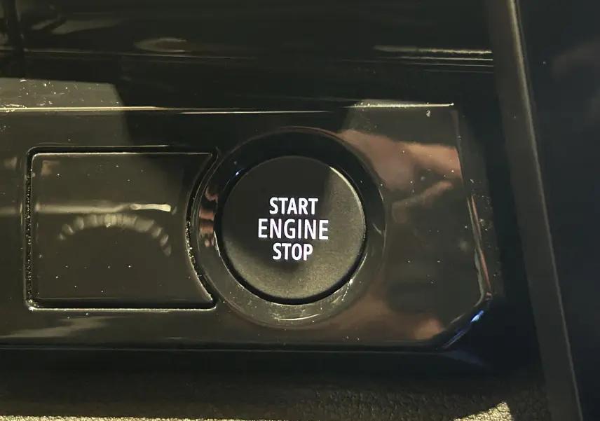 Bouton Start Engine Stop en gros plan sur la console intérieure noire d'un Renault Austral 2024.
